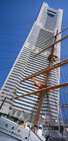 JAPAN, Honshu, Yokohama, View of the Nippon Maru tall ships mast with Landmark Tower skyscraper behind