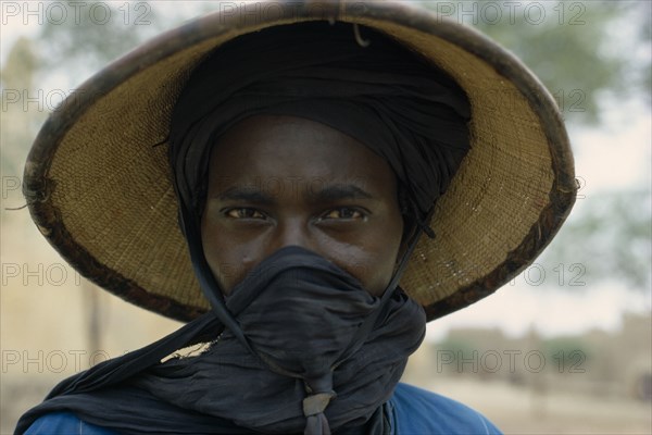 NIGERIA, People, Women, Portrait of a Fulani woman wearing a hat with a scarf covering her mouth.