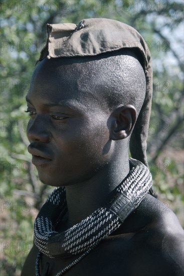 NAMIBIA, Skeleton Coast, Hoarusib Valley, Kaokoland.  Portrait of Himba man.  Cloth covering head denotes that he is married.