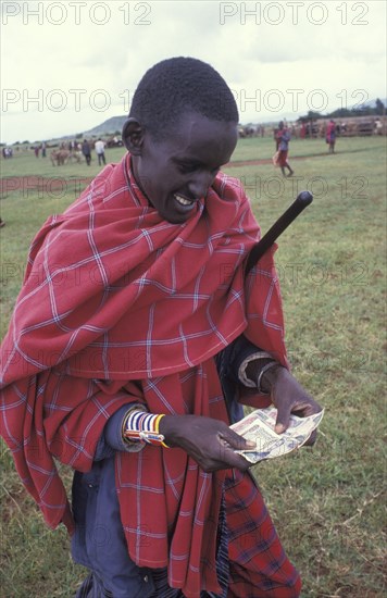 KENYA, , A Maasai man counts money from the sale of his cattle at a cattle market in Southern Kenya. Traditionally a Maasai mans wealth is measured by his number of cattle.