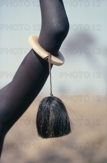 SUDAN, Body Decoration, Detail of ivory bracelet worn by Dinka woman from the Agar tribe decorated with tassle made from cattle or buffalo hair.