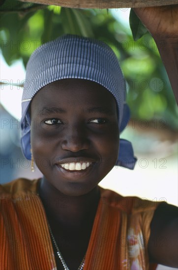 SUDAN, People, Portrait of smiling Dinka girl wearing striped headscarf.