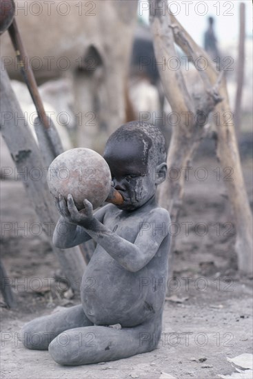 SUDAN, Tribal Peoples, Dinka child drinking milk from gourd.