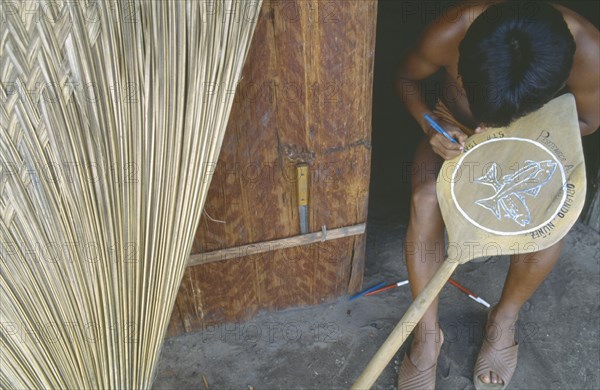 COLOMBIA, Amazonas, Santa Isabel, A Macuna Indian painting design depicting fish onto wooden oar.