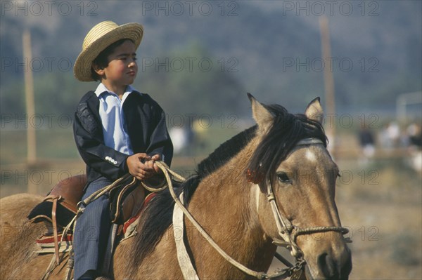 CHILE, Santiago, La  Barnechea, Young boy on horseback at the Fiesta de Cuasimodo held a week after Easter.