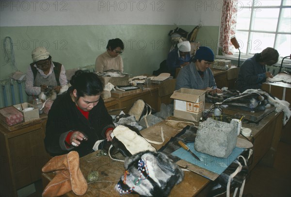 RUSSIA, Siberia, Kamchatka, Lesnoe.  Workers in factory making boots and hats from reindeer skin.