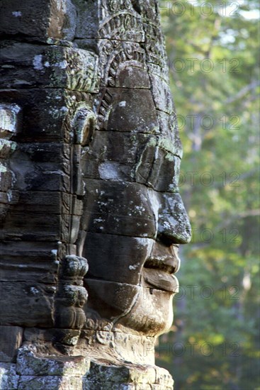 CAMBODIA, Angkor, The Bayon. One of the faces of the late twelth to early thirteenth century pyramid temple built in the centre of the ancient city of Angkor Thom