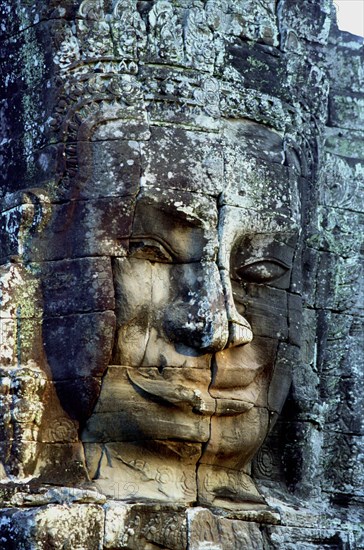 CAMBODIA, Angkor, The Bayon. One of the faces of the late twelth to early thirteenth century pyramid temple built in the centre of the ancient city of Angkor Thom