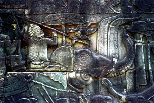 CAMBODIA, Angkor, The Bayon. Carved detail of the pyramid temple built in the centre of the ancient city of Angkor Thom depicting figure with spear riding an elephant