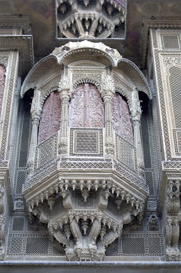 INDIA, Rajasthan, Jaisalmer, Detail of elaborate hand carved window frame of the Patwon Ki Haveli Mansion