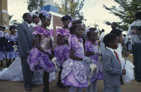 UGANDA, Rubanga, Christian wedding ceremony.  Bride and groom with bridesmaids and page boys outside cathedral.