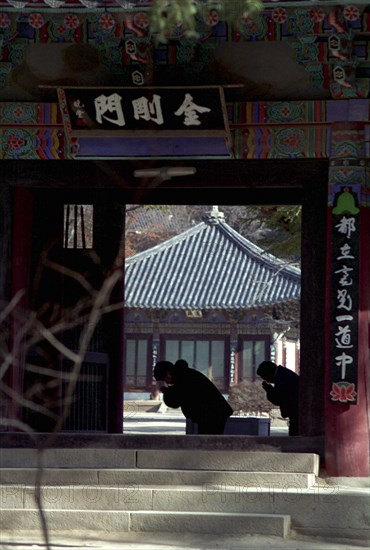 SOUTH KOREA, Songnisan National Park, Popchusa, View through Temple corridor with sillhouette of people in prayer