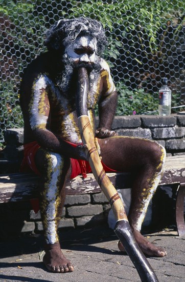 AUSTRALIA, New South Wales, Blue Mountains, Aborigine man with a didgeridoo busking for money at Katoomba main tourist centre