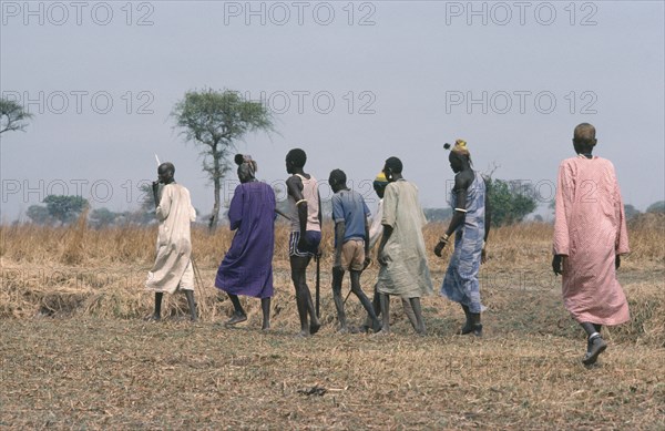 SUDAN, Wedding, Dinka bridegroom in purple with members of his clan who will negotiate a bride price in the form of a dowry of cattle.
