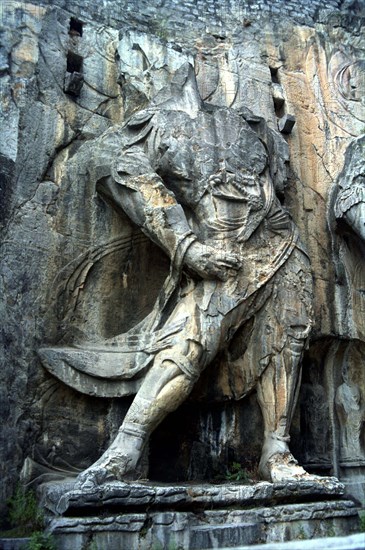 CHINA, Henan, Near Luoyang, Ancient Longmen caves. One of the many beheaded images of Buddha and his disciples carved in to the cliff wall