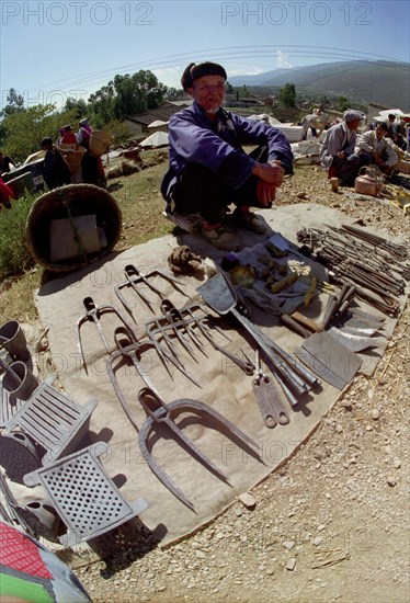 CHINA, Yunnan, Shapin, Wide angle view of market stall vendor and display of tools