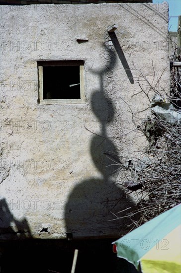 CHINA, Xinjiang, Kashgar, Shadow cast on a building wall of an Islamic crescent moon symbol usually found on a temple spire