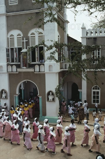 GHANA, Religion, Easter, Women in traditional pink dress leaving the Easter Sunday service