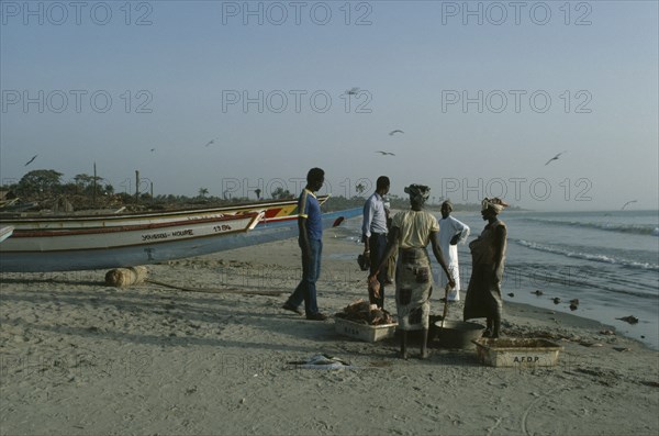GAMBIA, Gunjar, People buying freshly caught fish on the beach