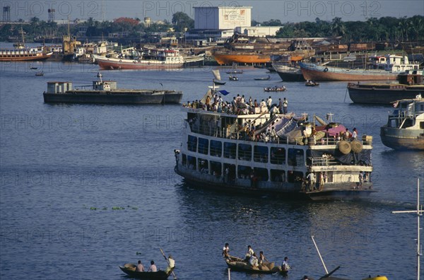 BANGLADESH, Dhaka, Crowded steamer leaving the Sadarghat terminal for the south.  People camped under makeshift tents on top deck.