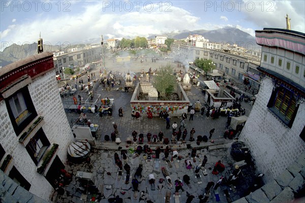 CHINA, Tibet, Lhasa, Wide angle view from the rooftop of the Jokhang Temple over people lying prostrate in front