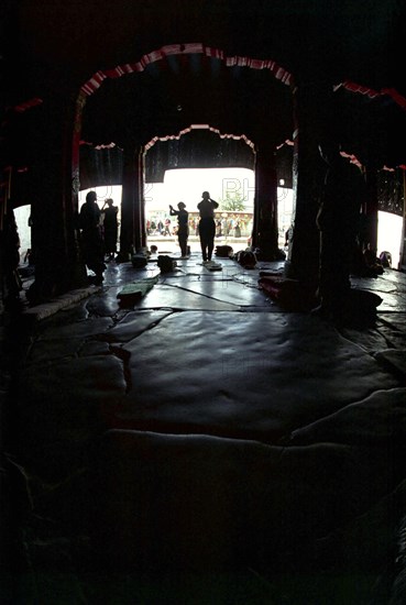 CHINA, Tibet, Lhasa, View looking out from inside the Jokhang Temple with people prostrating themselves in the entrance way