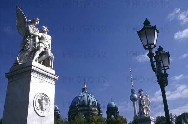 GERMANY, Berlin, Statues and street lamps on Schlossbrucke or Castle Bridge with the dome of the Cathedral and the Alexanderplatz Television Tower in the background