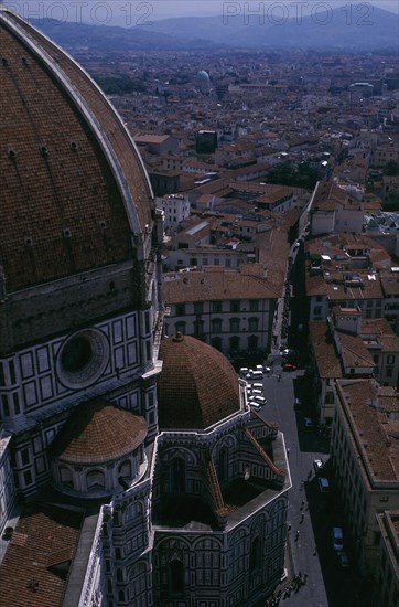 ITALY, Tuscany, Florence, Aerial view of the city streets seen past the domed roof of the Duomo from Giottos Tower