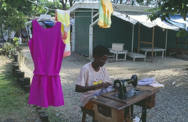 JAMAICA, Ocho Rios, Dressmaker working outside at hand operated sewing machine.