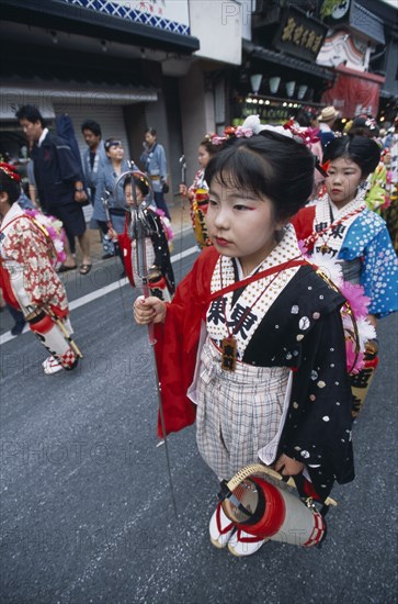 JAPAN, Chiba, Narita, 10-12 year old girls called tekomae in traditional kimono walking in front of dashi or wagons during the July Gion Matsuri