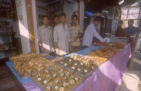 BANGLADESH, Dhaka, Street side shop selling snacks for Iftar. The sunset breaking off the fast in the Islamic Ramadan.