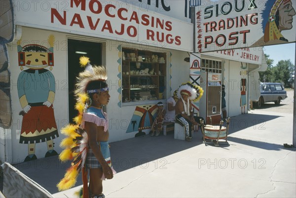 USA, Indigenous People, Native American Indian man and boy in costume outside Sioux and Navajo trading post