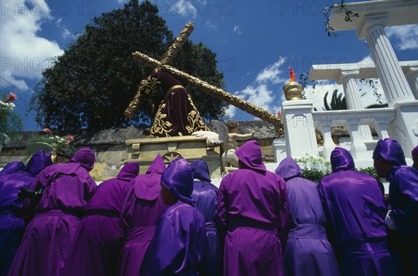 GUATEMALA, Antigua, Easter procession with man carrying wooden cross