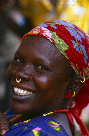 MALI, Body Decoration, Smiling African woman wearing floral headscarf and small gold nose ring through her septum