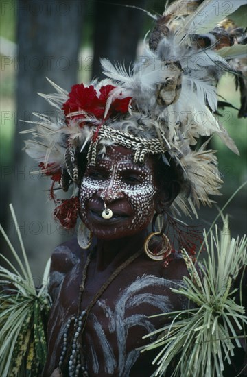 PAPAU NEW GUINEA, Karawari River, Ymas Two Village, Woman decorated with feathered hat white face paint and jewellery at the welcome dance
