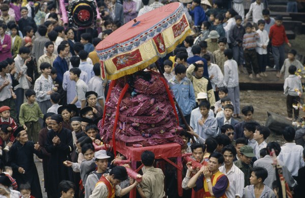 VIETNAM, North, Huge firecracker  being carried through the street at the Firecracker Festival during Tet New Year