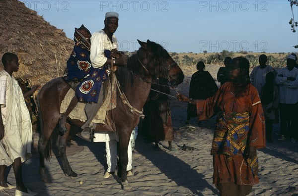 CHAD, Wedding, Arranged marriage mock abduction with fourteen year old bride taken away on horseback by her new husband to his village.