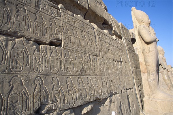 EGYPT, Nile Valley, Karnak, Precinct of Amun.  Detail of relief carving and hieroglyphics along wall of building leading to colossi.