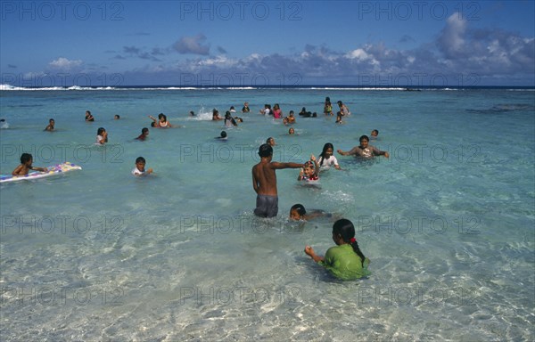 PACIFIC ISLANDS, Polynesia, Cook Islands, Atiu. Girls swimming in the harbour.