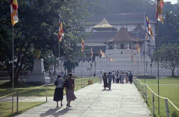 SRI LANKA, Kandy, People walking down flag lined walkway toward the Temple of the Tooth