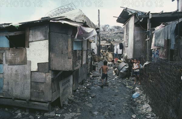 PHILIPPINES, Luzon Island, Manila, Smokey Mountain slum area.  Children in narrow alleyway between dilapidated shacks.