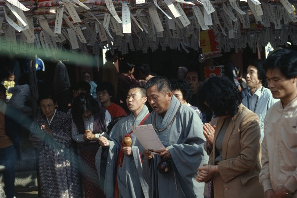 SOUTH KOREA, Religion, Buddhist, Korean Buddhist monk leads prayers during May celebrations of Buddhas birthday below ceiling hung with paper lanterns and prayer streamers.