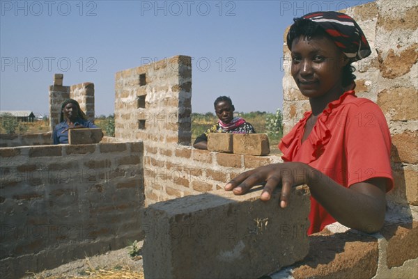 TANZANIA, Shinyanga, Mshikimano squatter settlement. Isabella Humbidi at site of new low cost house she and her husband are building after being taught how to make bricks and tiles.