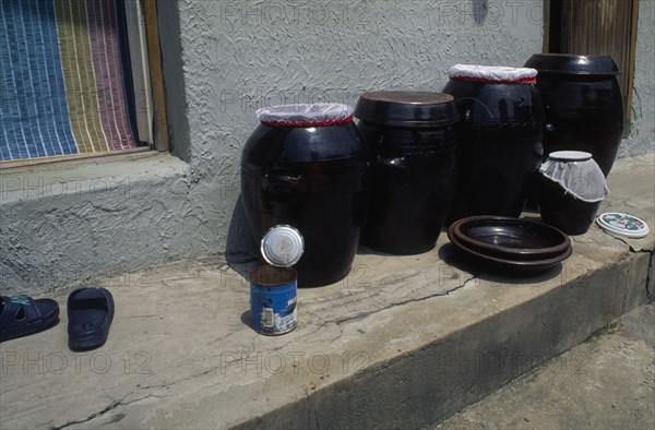 SOUTH KOREA, Sokcho, Ceramic jars of kimchi traditional pickled vegetables standing on doorstep of house in east coast fishing port.