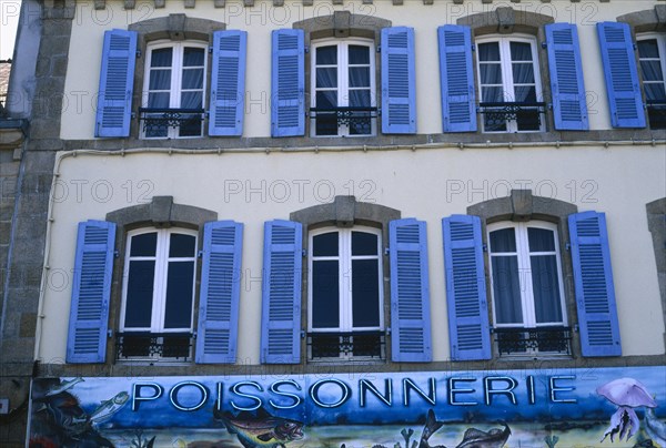 FRANCE, Brittany, Finistere, Douarnenez. Blue shuttered windows over Poissonnerie sign.