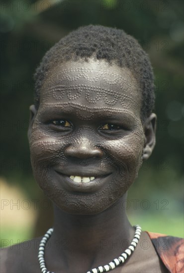 SUDAN, South, Portrait of a smiling Neuer girl with facial scarification