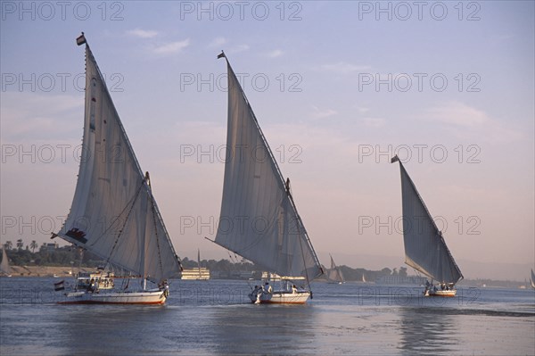 EGYPT, Nile Valley, Luxor, Line of three feluccas on the Nile.