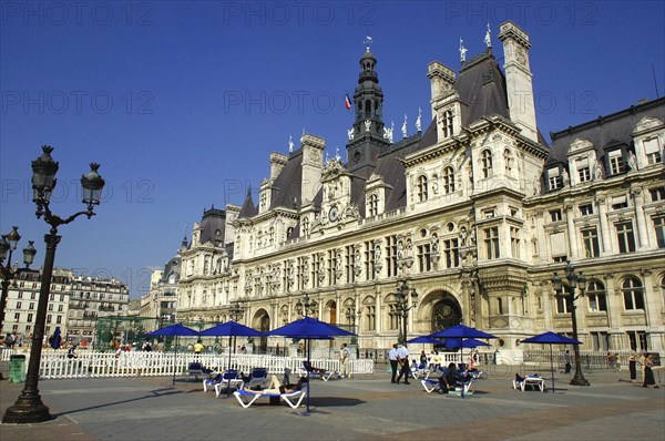 FRANCE, Ile de France, Paris, Hotel de Ville overlooking pedestrianized square with umbrellas and chairs