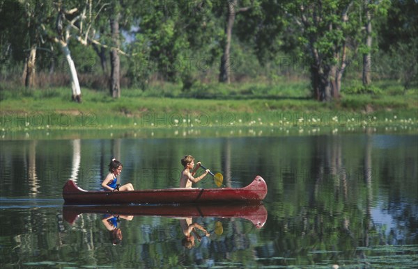 AUSTRALIA, Northern Territory, Children canoeing on Annaburroo Billabong near the Arnhem Highway at the Mary River Crossing between Darwin and Kakadu