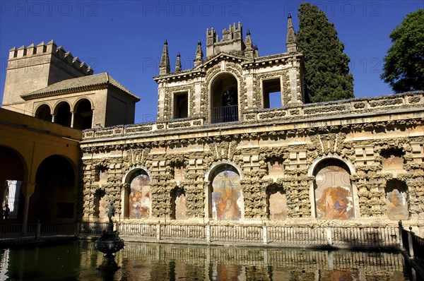 SPAIN, Andalucia, Seville, The Royal Alcazar exterior wall and pond